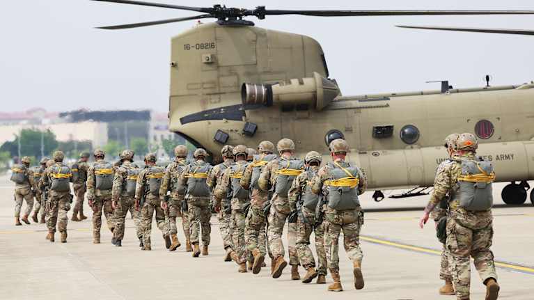 Joukko sotilaita kävelee helikopteriin.