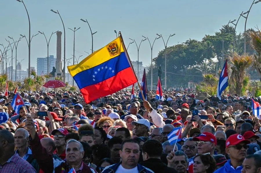 Cubans hold a Venezuelan national flag during a gathering in support of Venezuelan leader Nicolás Maduro in Havana on 3 January 2026, after US forces captured him. (Adalberto Roque/AFP)