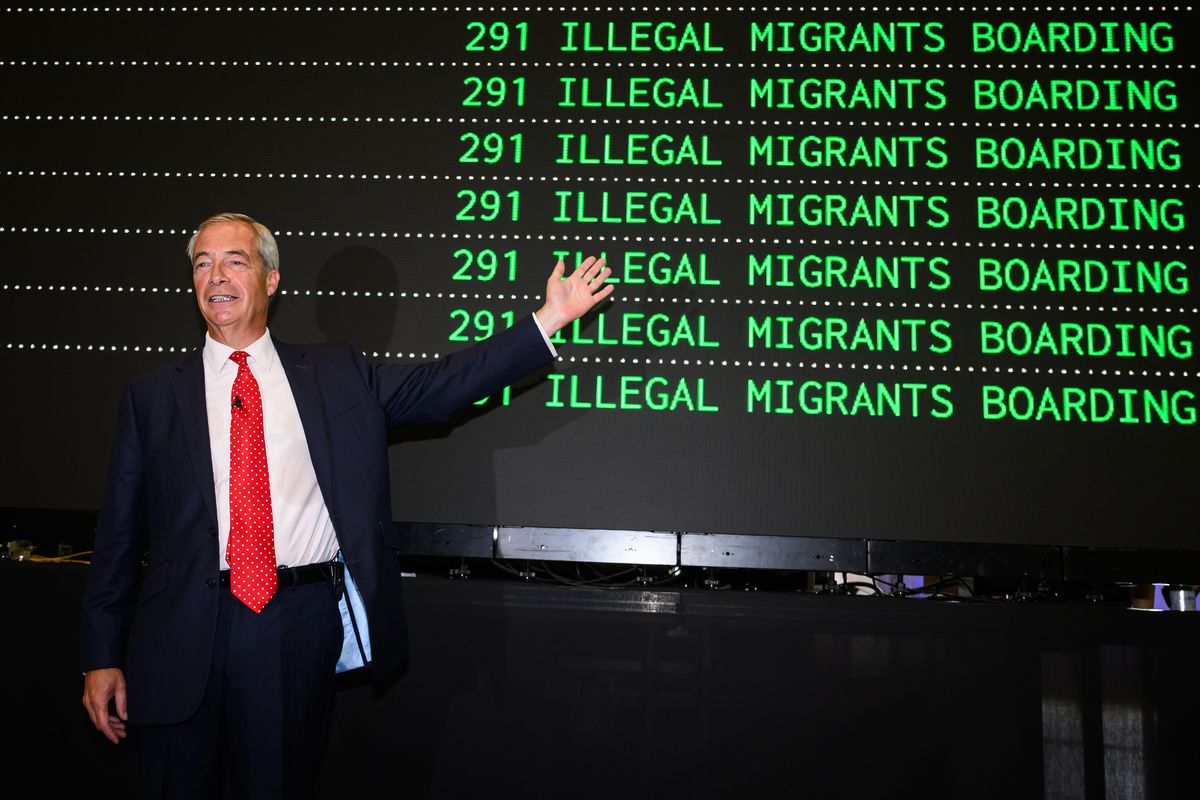 Nigel Farage poses in front of a mock departures board
