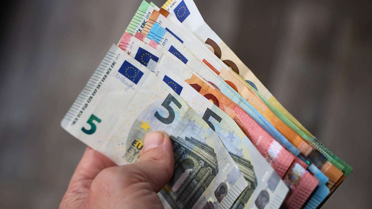 Person hält viele Euroscheine in der Hand.