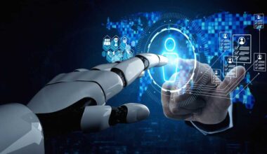 Robot hand and human hand extend toward either side of a virtual touchscreen to click a humanoid figure on the screen.