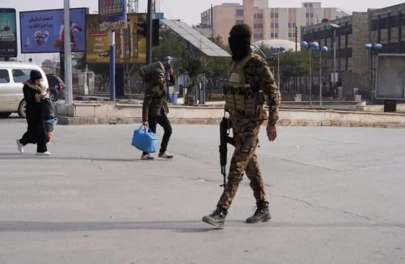 A member of the Syrian army walks with a weapon in the street as civilians flee following renewed clashes between the Syrian army and the Syrian Democratic Forces (SDF), in Aleppo, Syria, January 7, 2026 (credit: REUTERS/KARAM AL-MASRI)