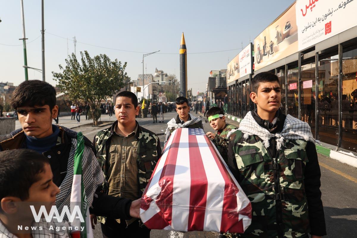 Members of Basij paramilitary forces hold a coffin with the U.S. flag during an anti-Israel rally in Tehran/WANA (West Asia News Agency)