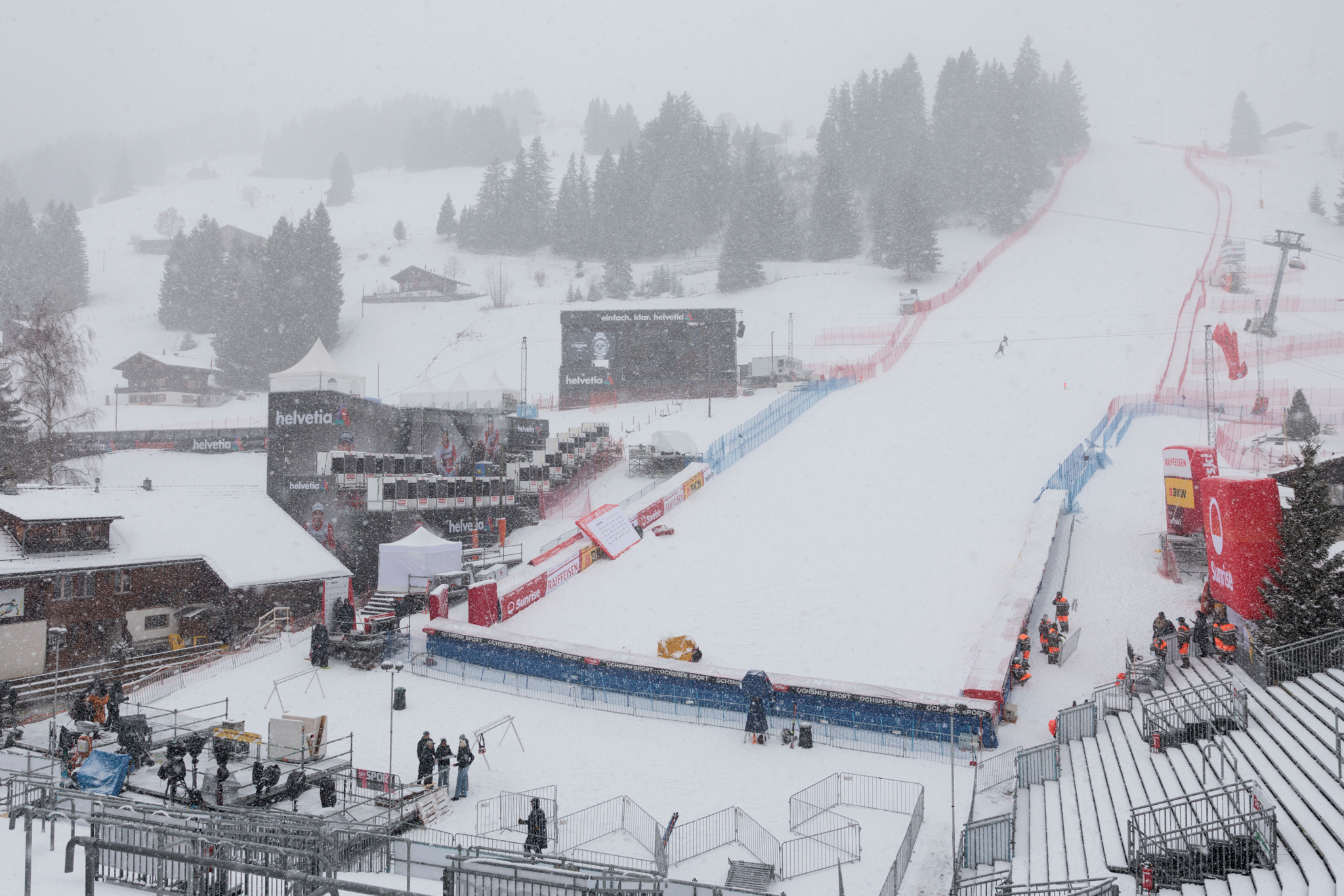 Zielraum beim Ski Weltcup Adelboden 2026 unter Schneefall, mit leeren Zuschauertribünen und schneebedeckten Hängen.