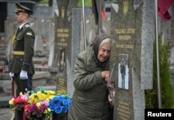 At a cemetery in Lviv, in western Ukraine, a woman visits the grave of a relative killed fighting against the Russian invasion, on May 23, 2025.