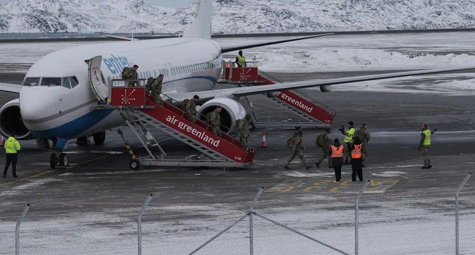 Military personnel believed to be from the German armed Forces Bundeswehr disembark a charter plane upon arrival at Nuuk international in Greenland on Friday (AFP via Getty Images)