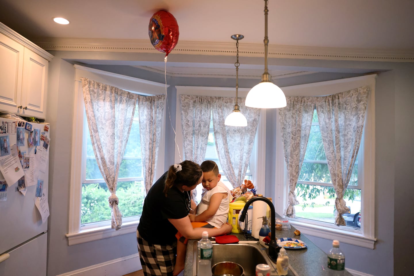 Christina Toledo, 38, (left) comforted her son, Jhon, 4, after he refused to blow out the candles on his birthday cake with his twin brother in Milford on June 11.