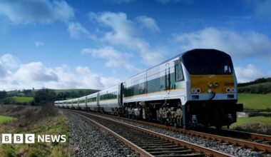 An Enterprise train on a track. It is yellow and green.