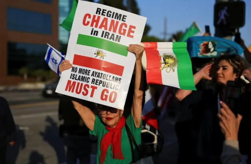 A demonstrator holding an Israeli flag and an Iranian flag from the reign of Shah Mohammed Reza Pahlavi takes part in a protest against the Iranian government outside the Federal Building in Los Angeles, California, US June 23, 2025. (credit: REUTERS/DAVID SWANSON)