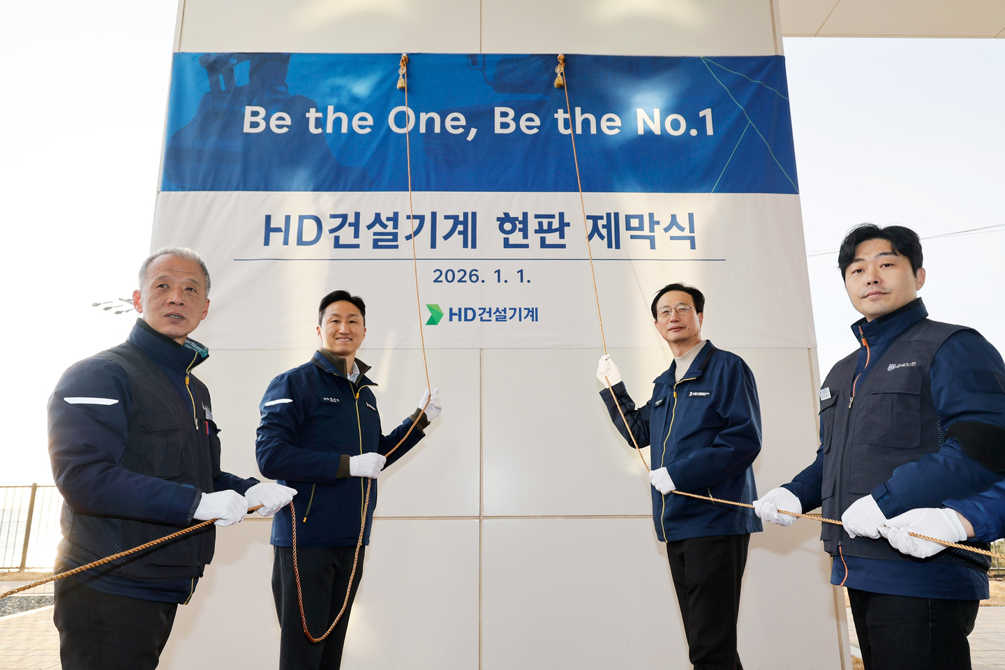 HD Hyundai and HD Construction Equipment executives including Chung Ki-sun, second from left, chairman of HD Hyundai, and Moon Jae-young, third from left, CEO of HD Construction Equipment, pose for a photo during a ceremony to unveil a plaque at the company's Ulsan Campus on Jan. 1. [HD HYUNDAI]