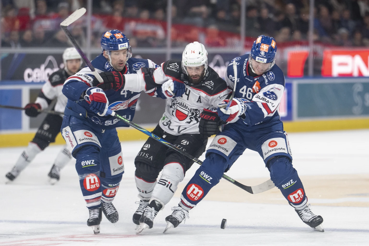 Patrick Geering (ZSC), Jason Fuchs (LHC) und Dean Kukan (ZSC), von links, kampfen um den Puck bei dem Spiel der Eishockey National League zwischen den ZSC Lions und dem Lausanne HC am Samstag, 3. Janu ...
