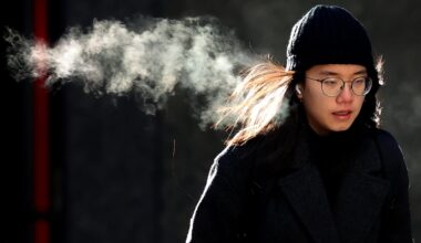 A person walks in downtown Boston during a frigid December day. To understand how a warming climate can unleash bitter cold, some experts are looking to the winds that circle the Arctic.
