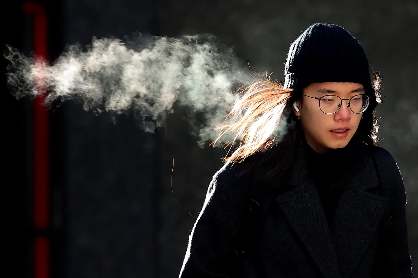 A person walks in downtown Boston during a frigid December day. To understand how a warming climate can unleash bitter cold, some experts are looking to the winds that circle the Arctic.