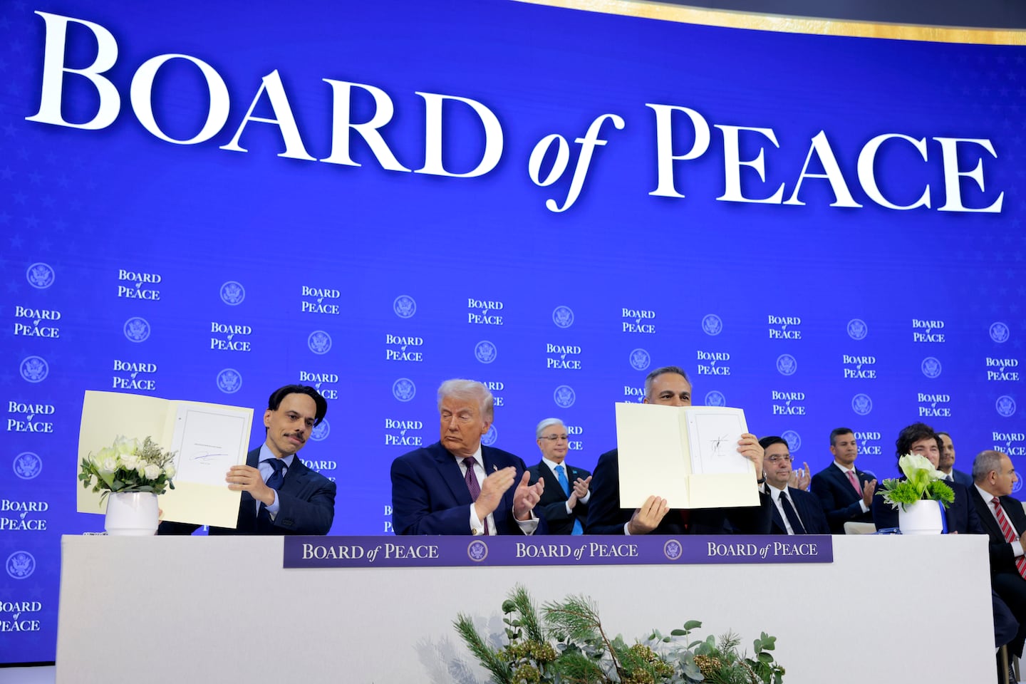 Saudi Arabia's Foreign Minister Faisal bin Farhan (L) and Turkey's Foreign Minister Hakan Fidan join President Trump during a signing ceremony for the “Board of Peace” at the World Economic Forum (WEF).