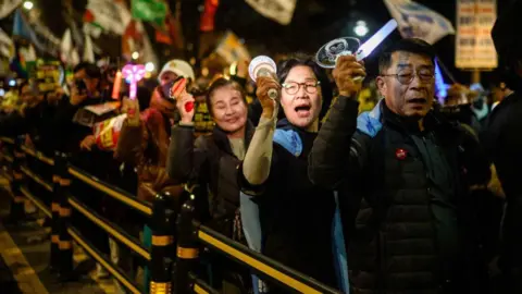 AFP via Getty Images Anti-Yoon protesters march at a rally in Seoul in March 2025, ahead of the impeachment verdict for South Korean president 