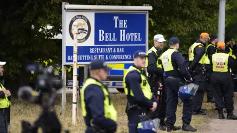 PA Media Police officers standing outside The Bell Hotel in Epping which was housing asylum seekers. There is a police presence while a demonstration is happening.