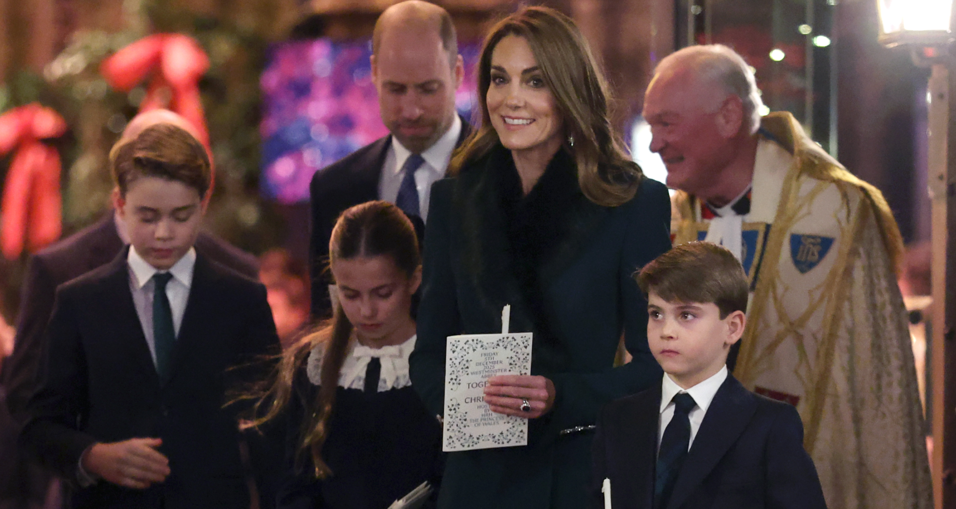 Prince George, Princess Charlotte and Prince Louis holding candles standing in front of Princess kate and Prince William