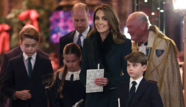 Prince George, Princess Charlotte and Prince Louis holding candles standing in front of Princess kate and Prince William
