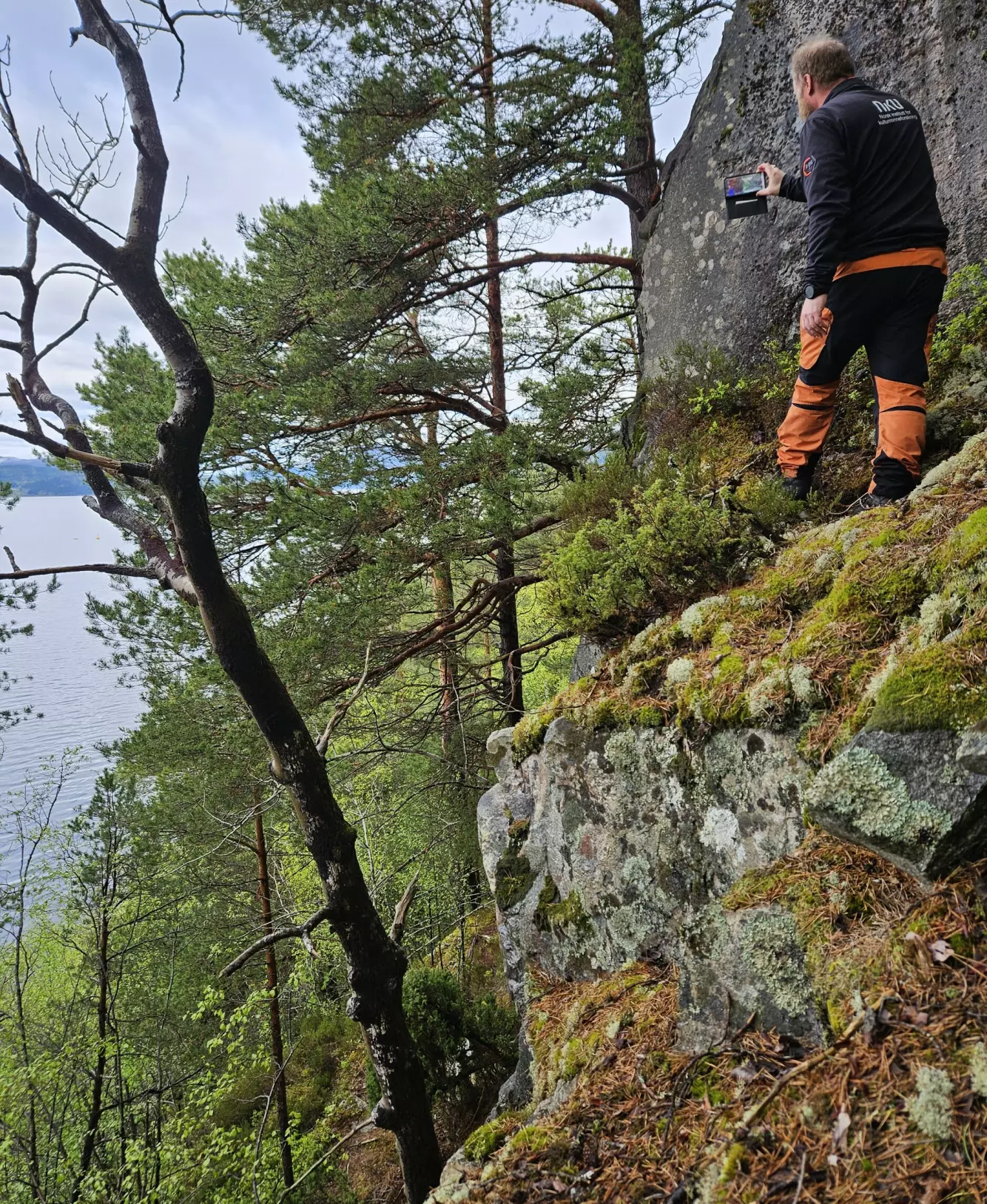 STUPBRATT: Det er ikke vanskelig å forstå at arbeidsforholdene ikke alltid er lette når man jobber med bergkunst. Foto: Dag-Øyvind Engtrø Solem / NIKU