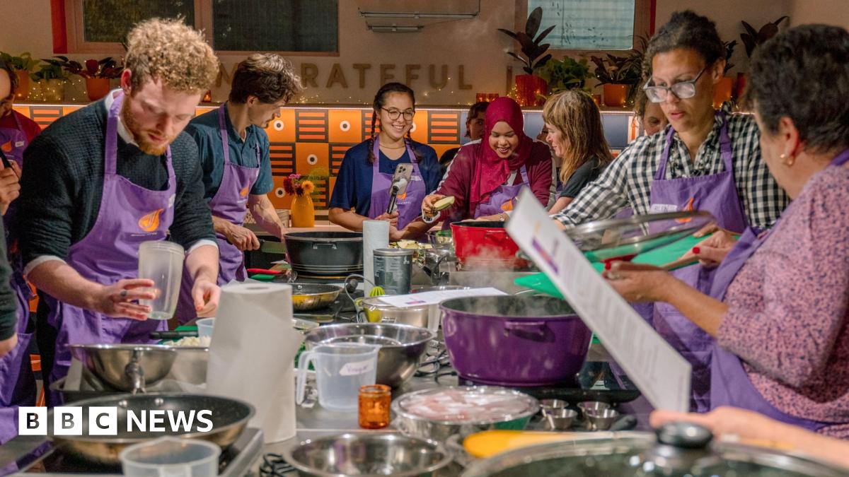 Mel Fu, Jenny Luk and Vicky Yung (L-R) are standing next to each other at a food stall. They are all smiling, with the two women on the right wearing striped aprons.