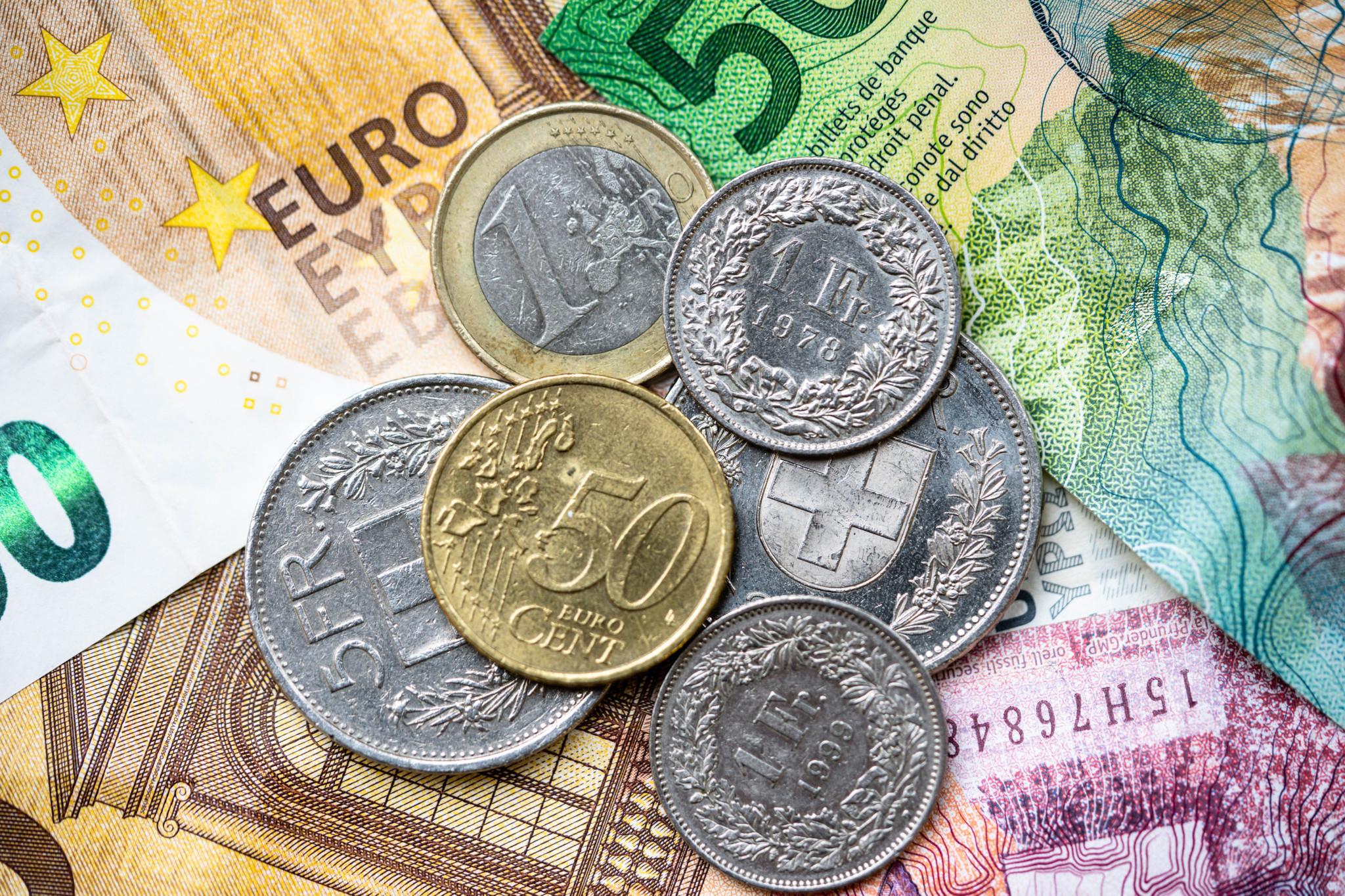 Schweizer Franken und Euro-Münzen sowie Banknoten nebeneinander angeordnet.