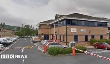 Brown brick office building with car park and barrier in front