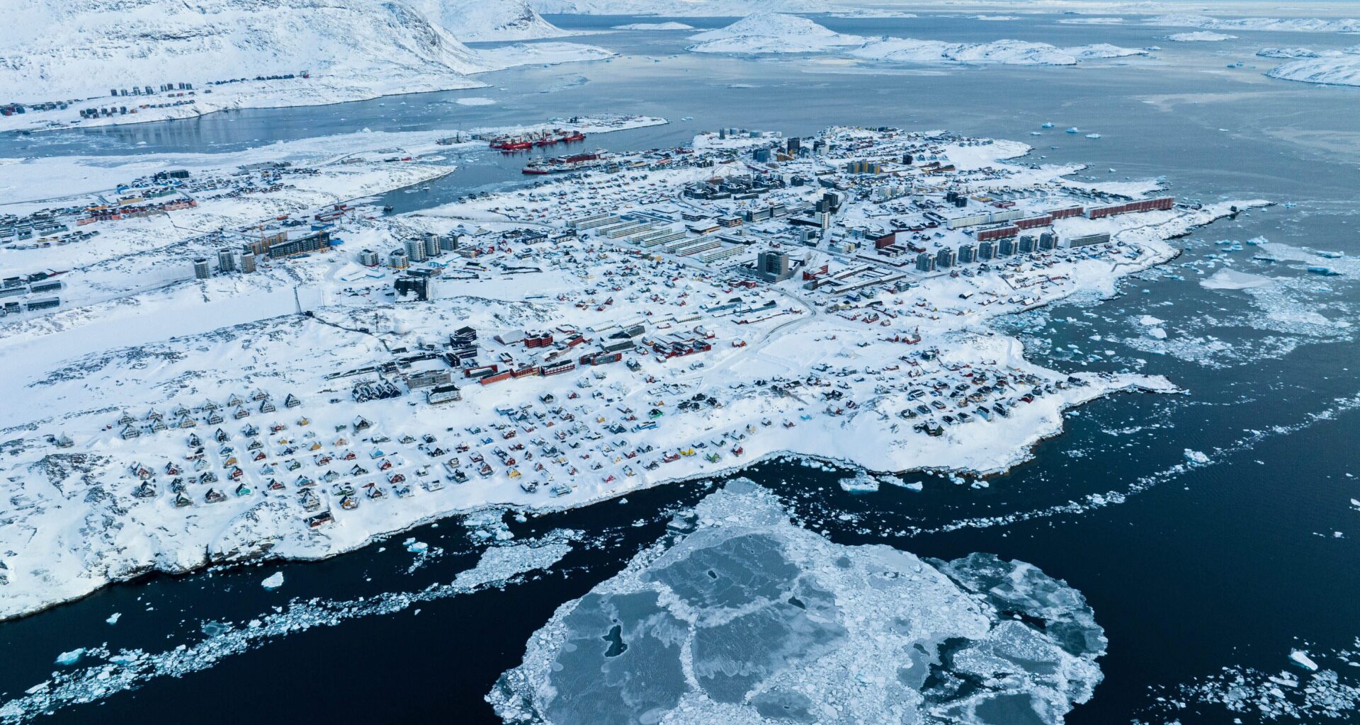 Houses covered by snow are seen on the coast of a sea inlet of Nuuk, Greenland.