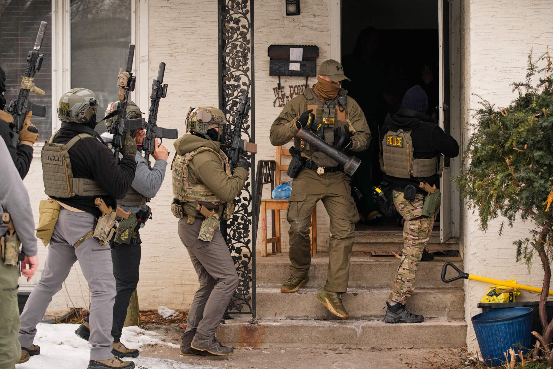 Federal immigration officers prepare to enter a home to make an arrest after an officer used a battering ram to break down a door Sunday, Jan. 11, 2026, in Minneapolis. (John Locher/AP)