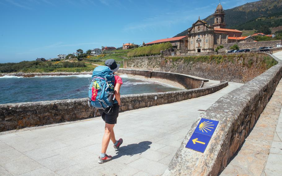The Camino de Santiago is a medieval pilgrimage route that uses stylized yellow shells on a blue background for trail markers.