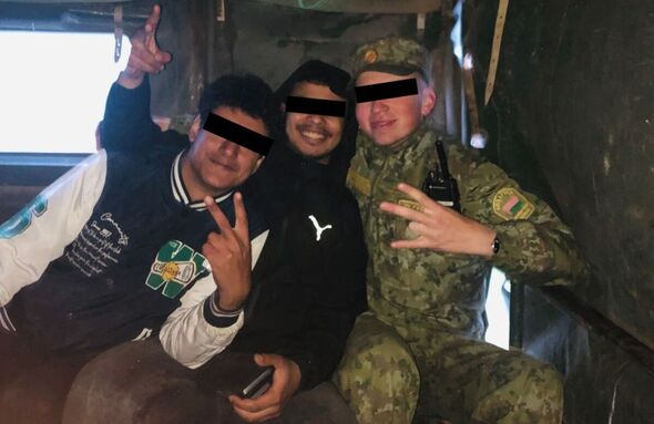Latvia says this image shows a Belarusian service member posing with migrants in a military vehicle