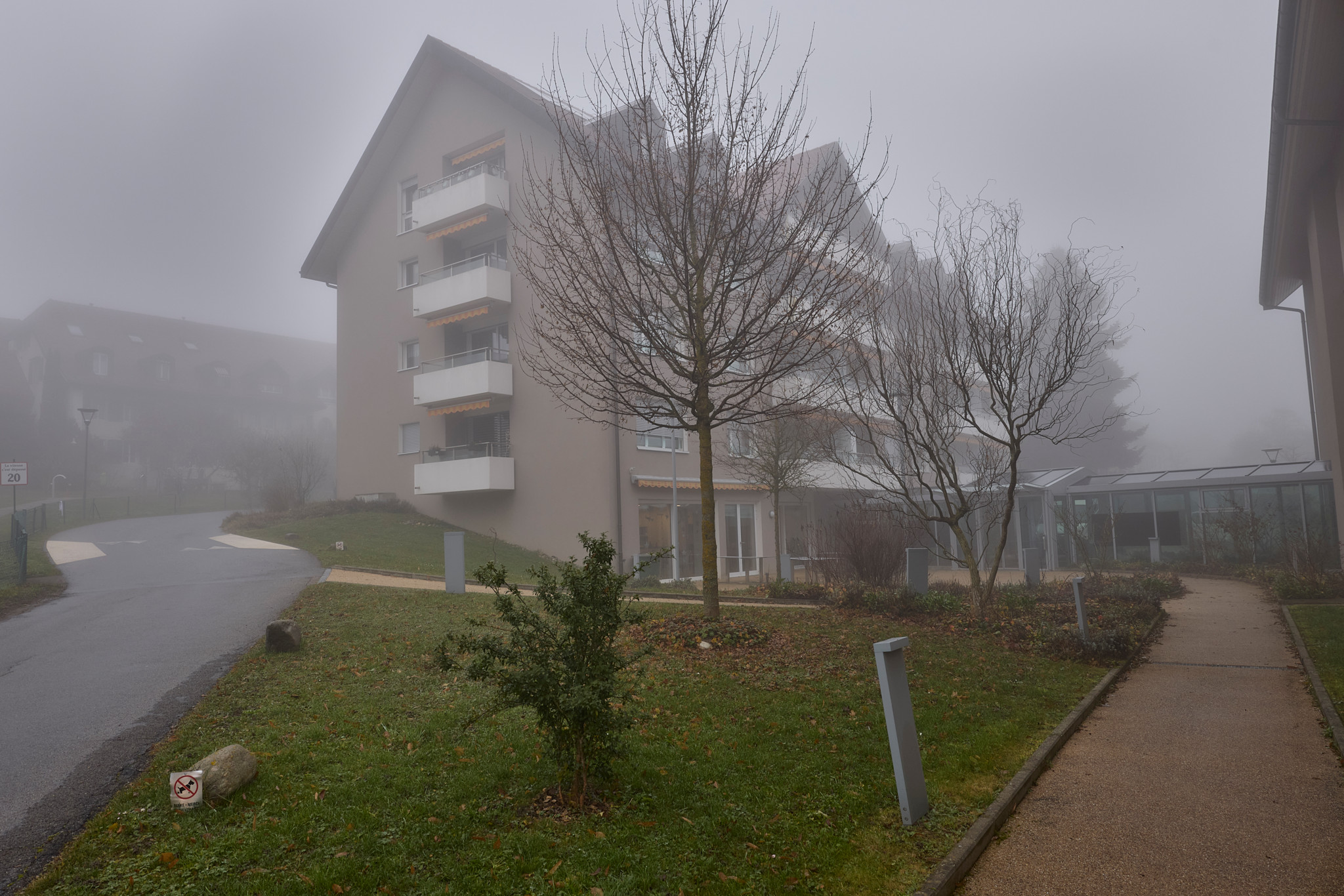 Bâtiment des logements protégés de l’EMS Fondation Baud à Apples, sous un ciel brumeux en décembre 2025.