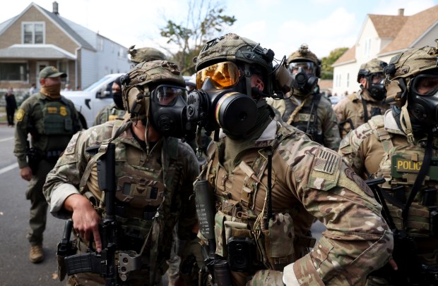 Border Patrol agents are confronted by community members in the 10500 block of South Avenue M on Oct. 14, 2025. (Terrence Antonio James/Chicago Tribune)