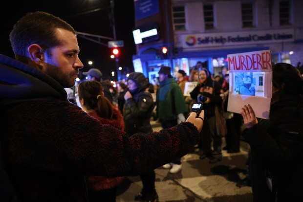 Andrew Freer of Go Fourth Media uses a small video camera to document a protest against ICE on 26th Street in Chicago's Little Village neighborhood in response to the shooting death of motorist Renee Nicole Good by a federal immigration agent in Minneapolis on Jan. 7, 2026. (Chris Sweda/Chicago Tribune)