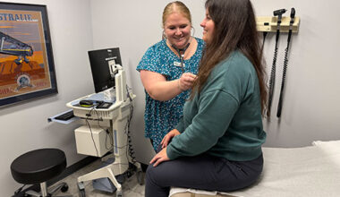 Photo: Employee at Champlain Medical Occupational Health & Urgent Care in South Burlington, checks in with a patient. VermontBiz photo.