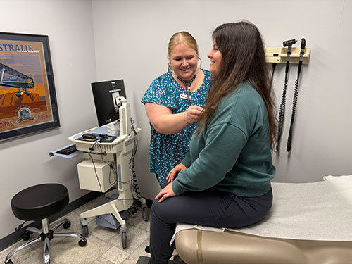 Photo: Employee at Champlain Medical Occupational Health & Urgent Care in South Burlington, checks in with a patient. VermontBiz photo.