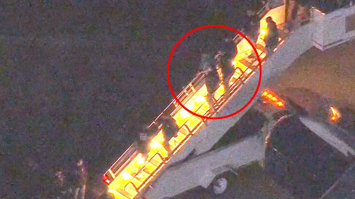 Et fly har nettopp landet, og flere personer er i ferd med å gå ned en trapp fra flyet. Svart bakgrunn indikerer at det er mørkt, mens trappen er belyst. Ingen ansikter er tydelige i bildet. Handlingen skjer i en flyplasssetting, med pressen til stede. (Bildebeskrivelsen er laget av en KI-tjeneste)