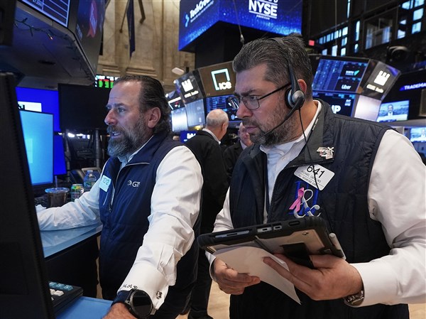 Stocks edge a bit below their latest records on Wall Street