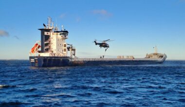 Finnish authorities repel from a helicopter onto the deck of the M/V Fitburg