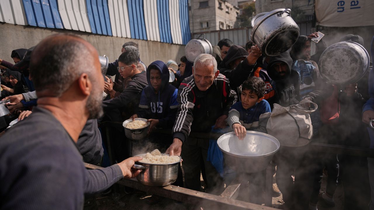 Palestinians receive donated food at a community kitchen in Nuseirat, in central Gaza Strip, Saturday, Jan. 24, 2026. (AP Photo/Abdel Kareem Hana)