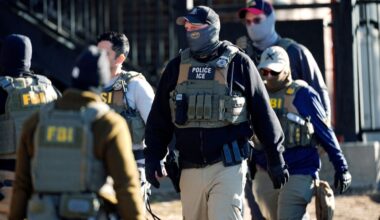 Law officials spread out through an apartment complex during a raid, Feb. 5, 2025, in east Denver. (AP Photo/David Zalubowski, File)
