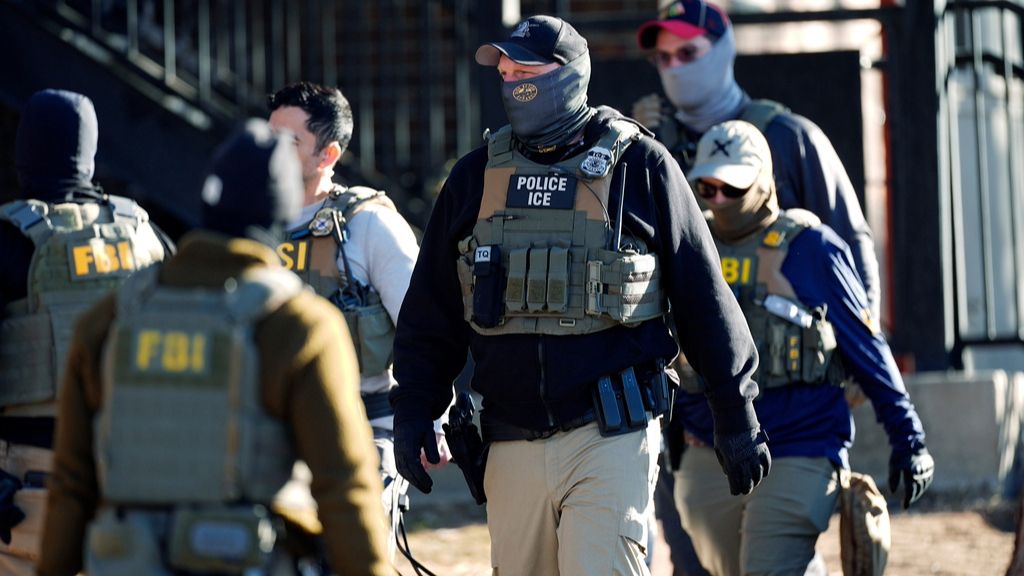 Law officials spread out through an apartment complex during a raid, Feb. 5, 2025, in east Denver. (AP Photo/David Zalubowski, File)