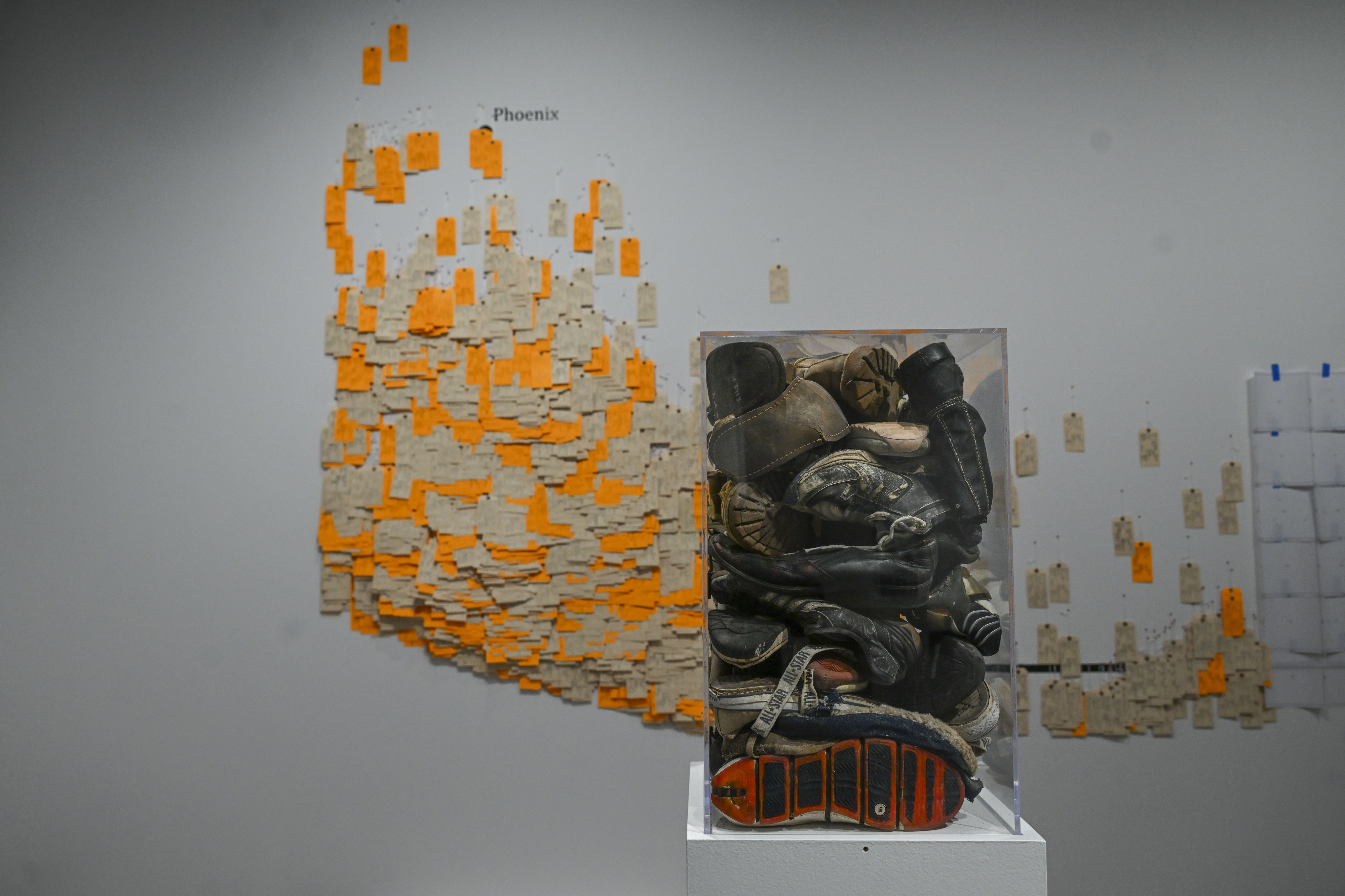 Remnants of shoes worn by traveling migrants are encased as...