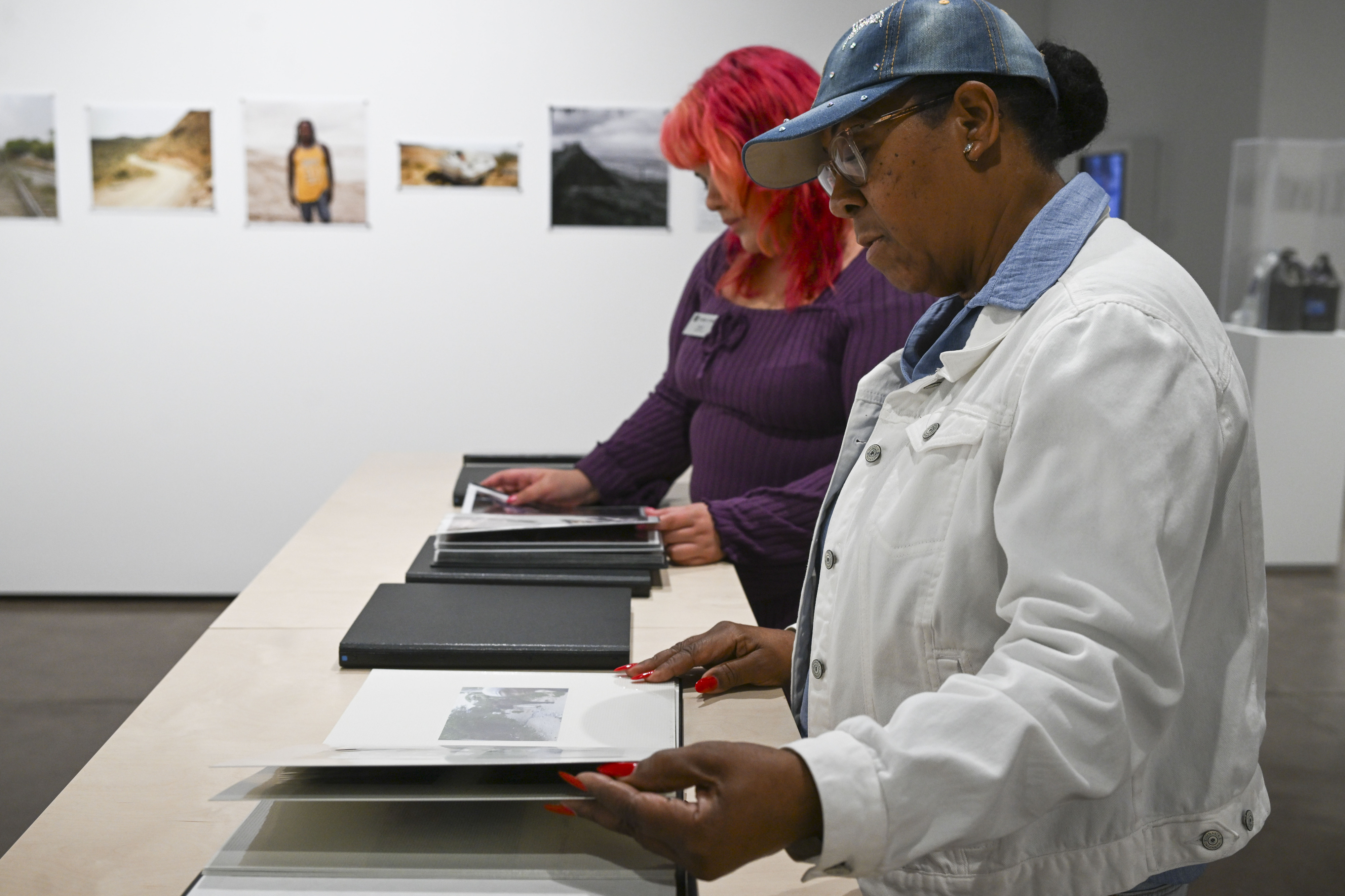 Mechell Prater and Lizzeth Camacho look through photographs taken by...