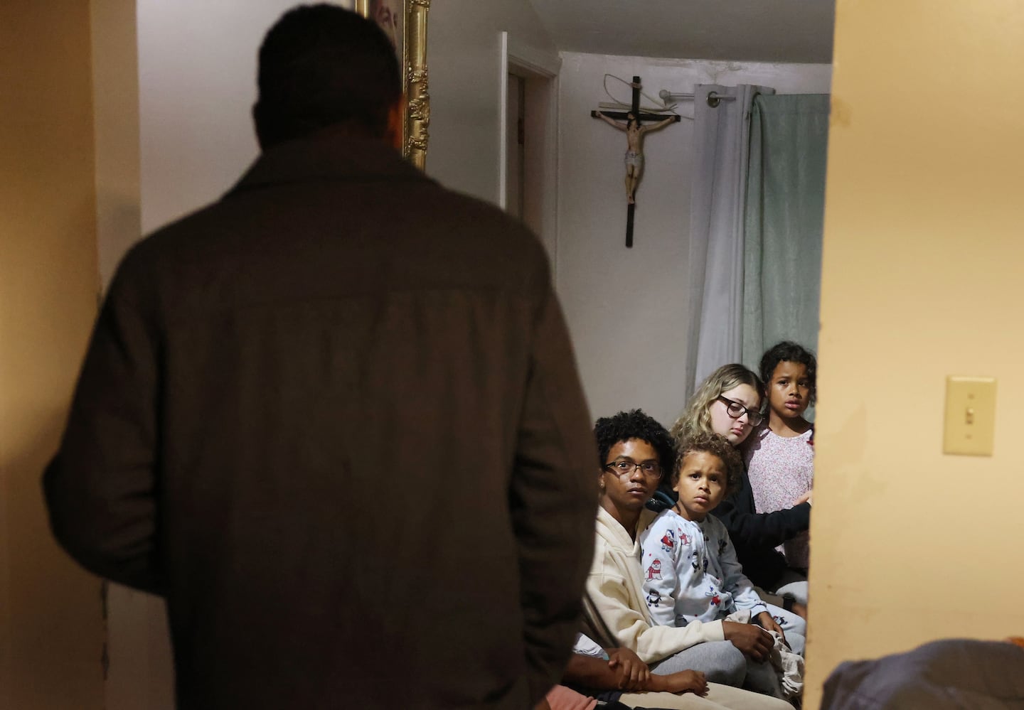 Frilei Brás lingered in the doorway of the kitchen as his daughters, Sarah, 9, (right), Clara, 19 (second from right) and his son Rafael, 4, sat with his daughter’s boyfriend and look back at him with pained expressions shortly before he will leave the house and his family for the last time in Stoughton on June 18.