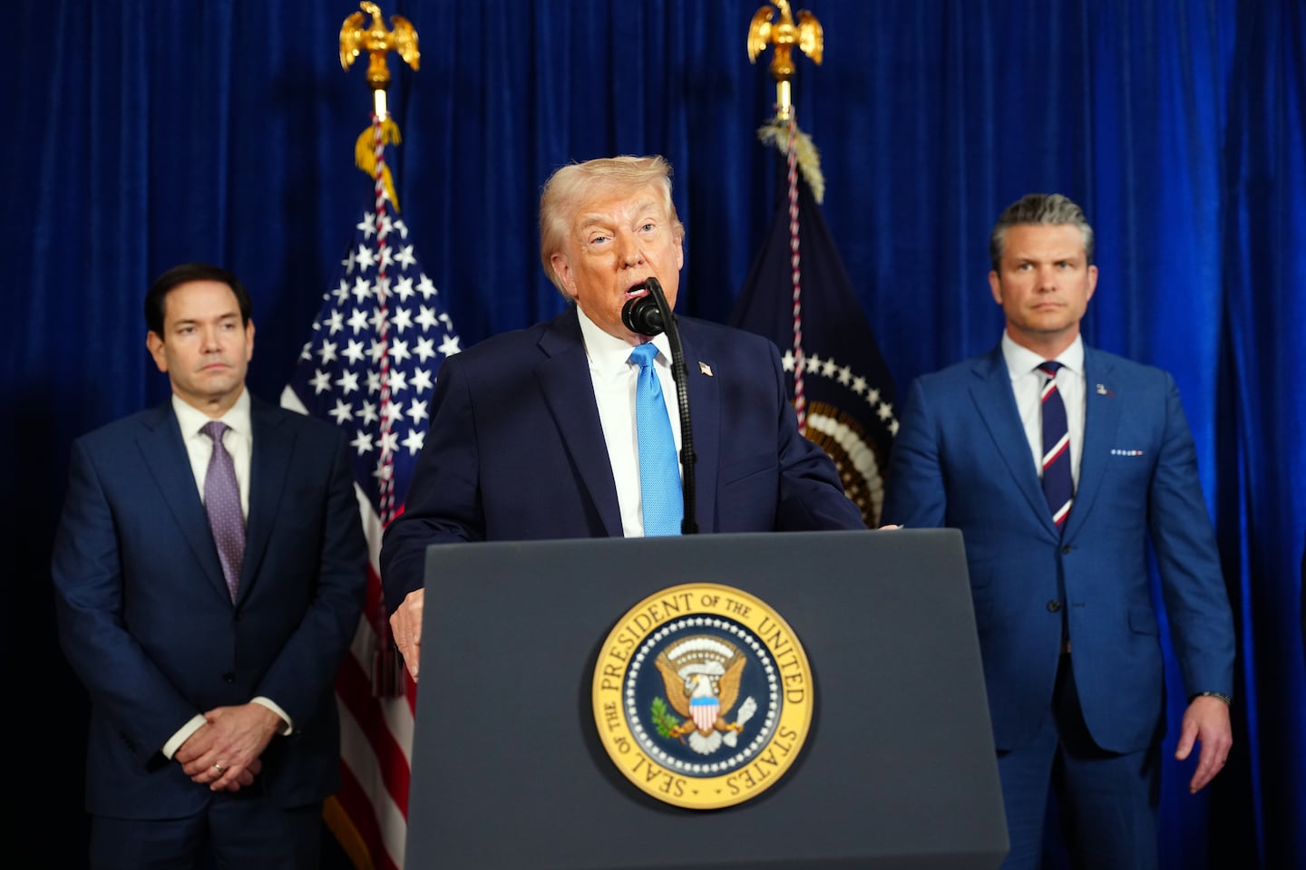 President Trump was flanked by Secretary of State Marco Rubio left, and Defense Secretary Pete Hegseth as he spoke at Mar-a-Lago, his private club and residence in Palm Beach, Fla., on Saturday.