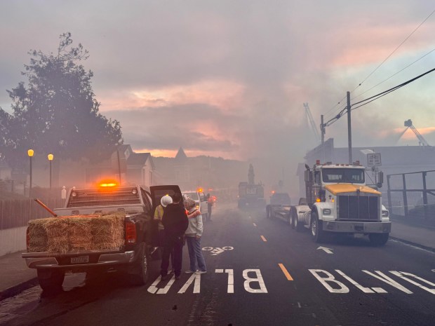 Crews worked to stage straw wattles and position excavators on the west side of the fire on the evening of Friday, Jan. 2. (Robert Schaulis/The Times-Standard)