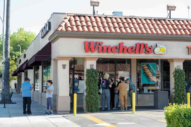 People gather in Pasadena where an ICE raid reportedly took place at the Winchell's Donut House on June 18, 2025. (Connor Terry, Contributing Photographer)