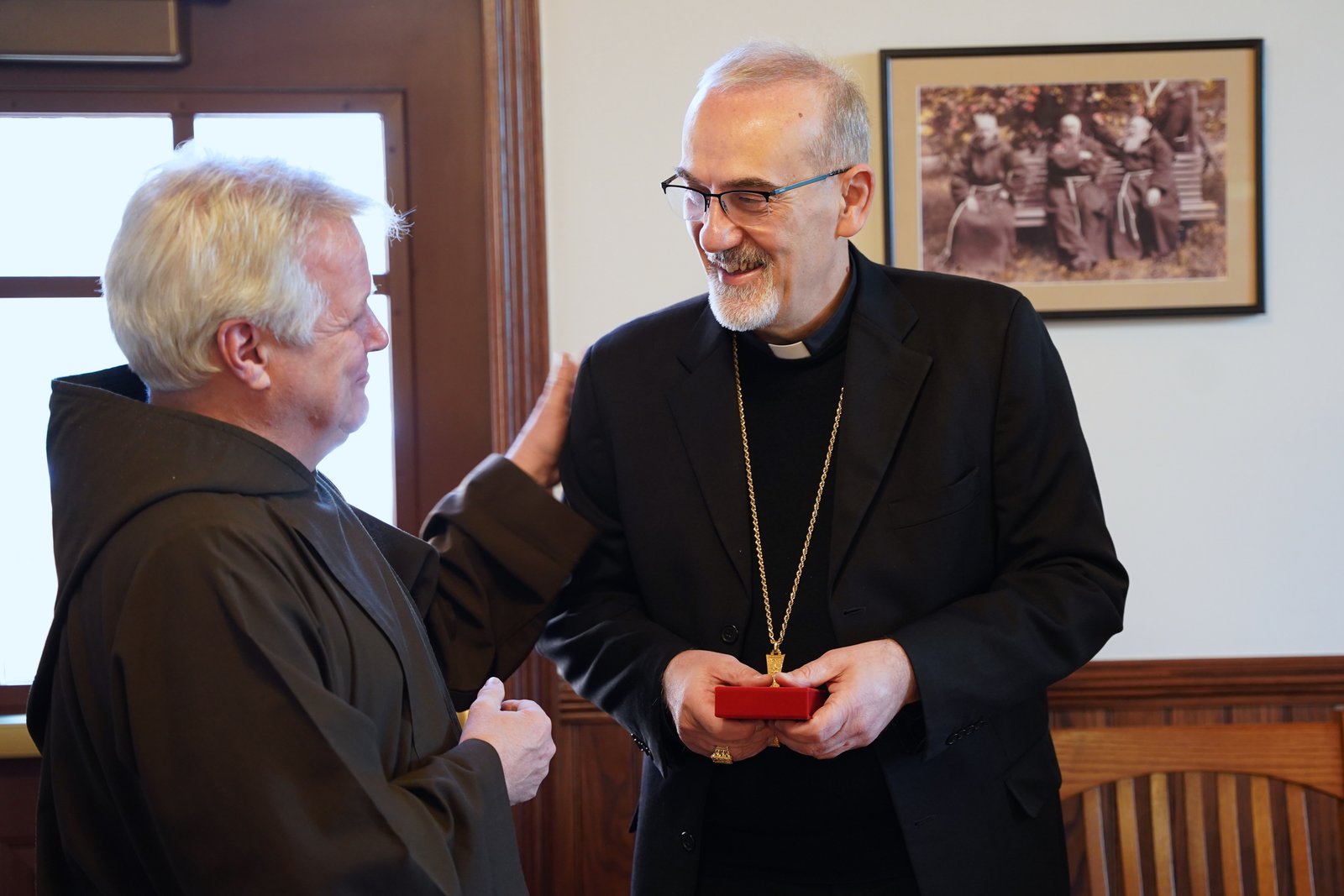 Fr. Mark Joseph Costello, OFM Cap., left, provincial minister of the Capuchin Franciscan Province of St. Joseph, gifts Cardinal Pierbattista Pizzaballa, OFM, the Latin Patriarch of Jerusalem, with a first-class relic of Blessed Solanus Casey during the cardinal's Dec. 5 visit to the Solanus Casey Center. (Photo by Daniel Meloy | Detroit Catholic)