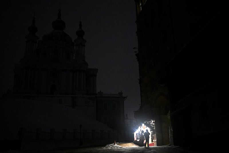 Pedestrians stand outside a bar in front of St Andrew's Church during a power outage in Kyiv on January 29th. Photograph: Sergei Gapon/AFP via Getty