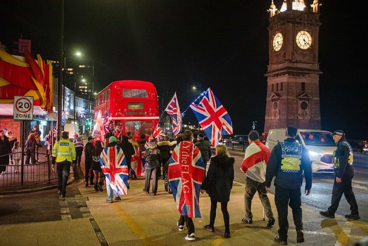 MARGATE, UNITED KINGDOM - 2025/12/22: Far-right protesters march with flags by the Clock Tower during the rally. Dozens of activists from the Kent Anti-Racism Network, Care4Calais, and Stand Up To Racism gathered in Margate to counter a small anti-immigration rally organized by the United Kingdom Independence Party (UKIP). The counter-protest featured prominent 